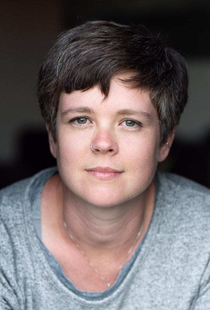 An image of a white woman with short brown hair looking directly at the camera.